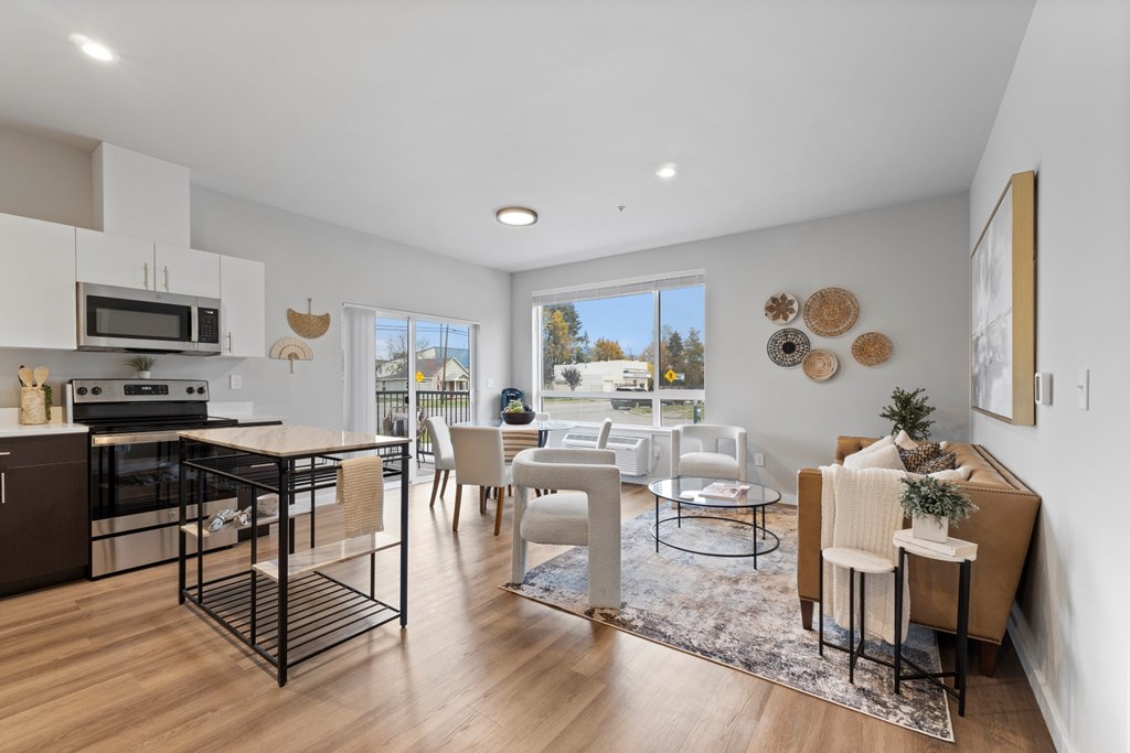 A modern kitchen with a dining area and a view of the outdoors.