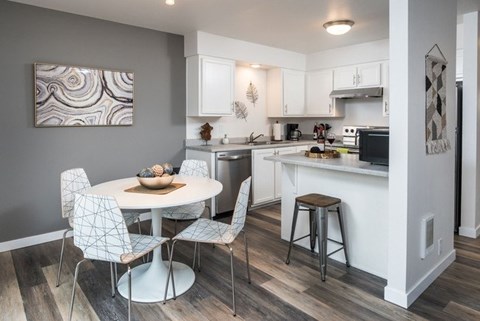 A modern kitchen with a dining table and chairs.