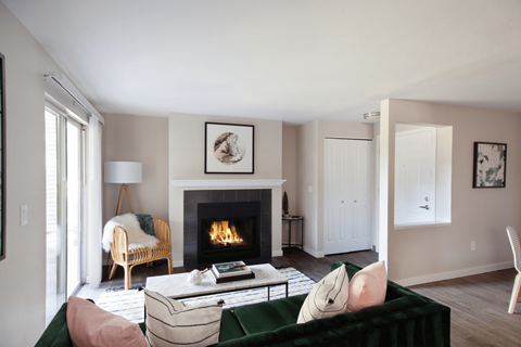 A living room with a fireplace and a green couch.