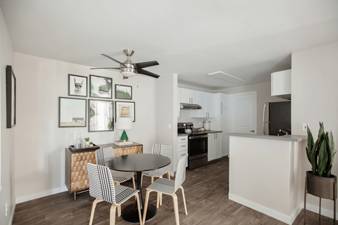 A modern kitchen with a dining table set for four.