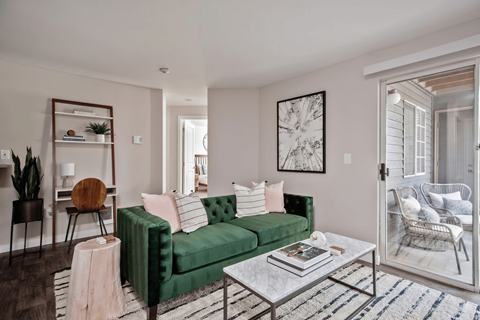A living room with a green couch, a coffee table, and a chair.