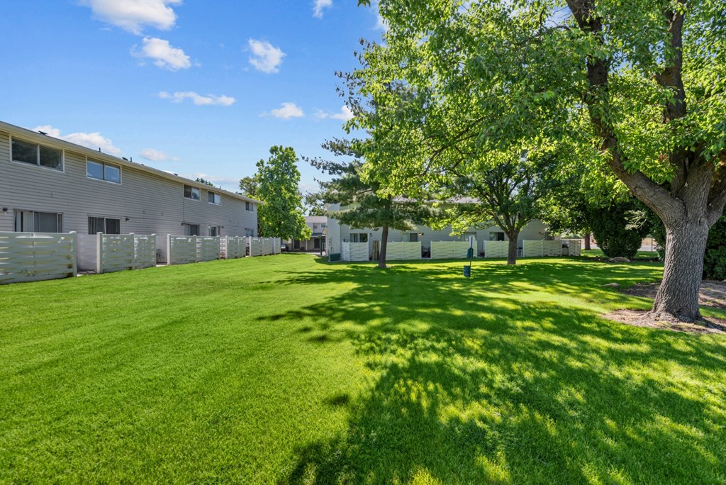 the backyard of a building with grass and trees