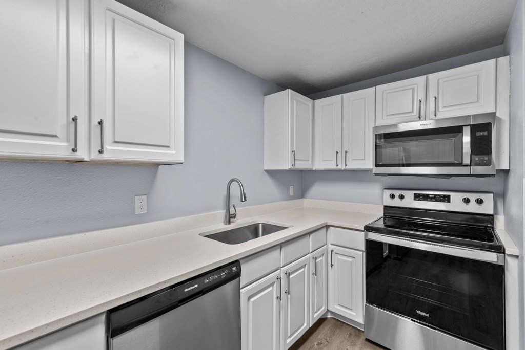 a kitchen with white cabinets and black and white appliances