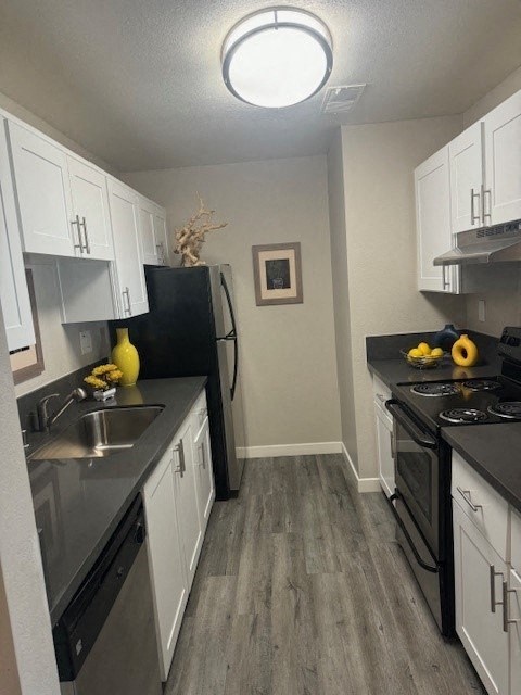 a kitchen with black appliances and white cabinets