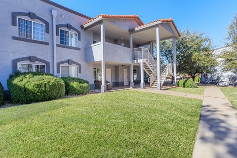 A two-story house with a red tile roof and a balcony on the second floor.