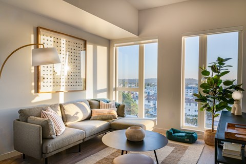 A living room with a grey couch and a wooden table.