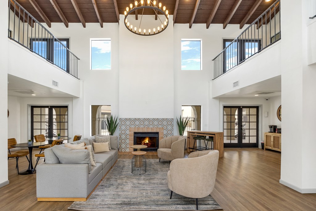 A modern living room with a fireplace and a large chandelier.