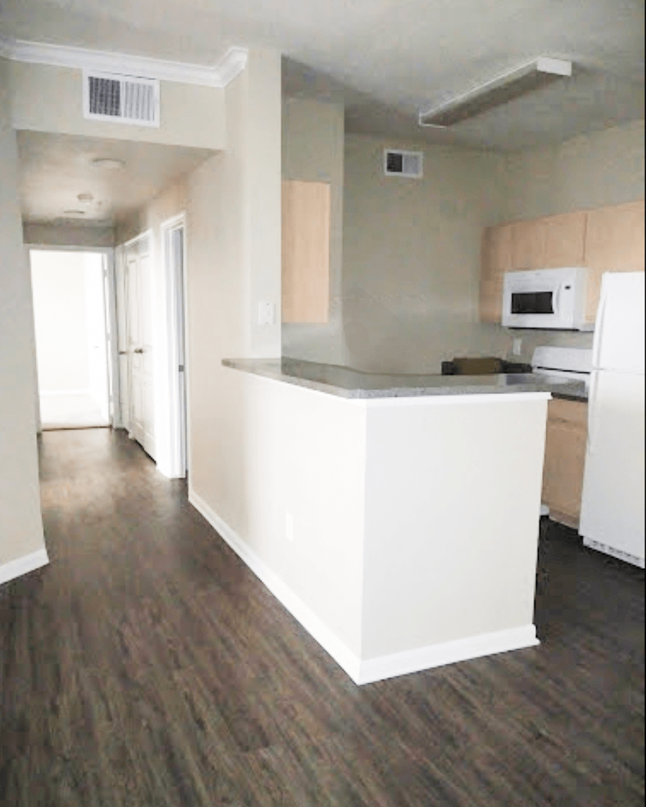 an empty kitchen with a counter and a microwave