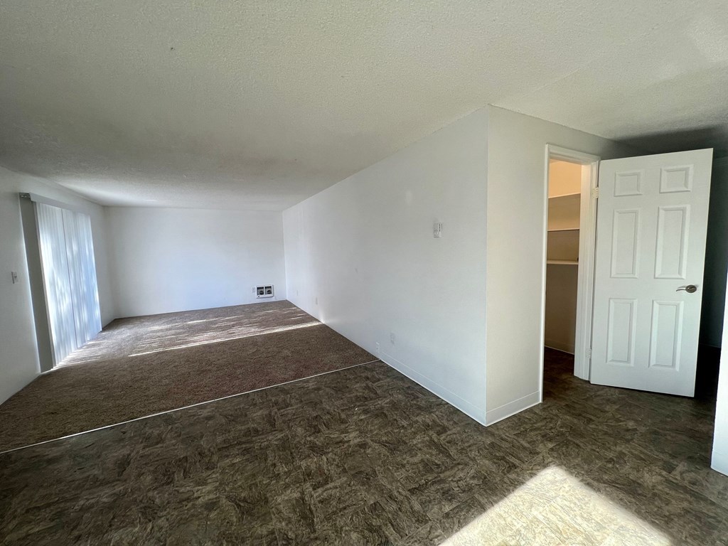 an empty living room with white walls and a white door