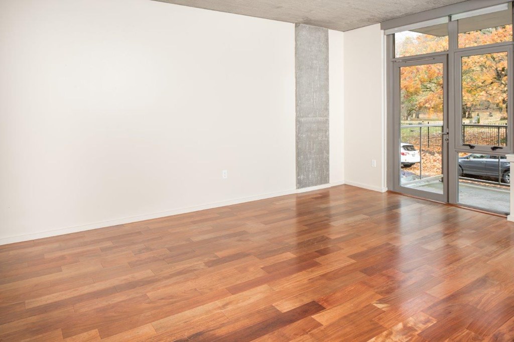 A room with wooden flooring and a sliding glass door.