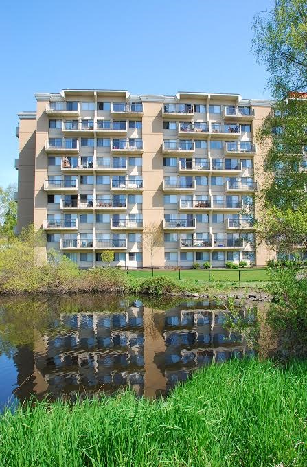 an apartment building with a reflection in the water