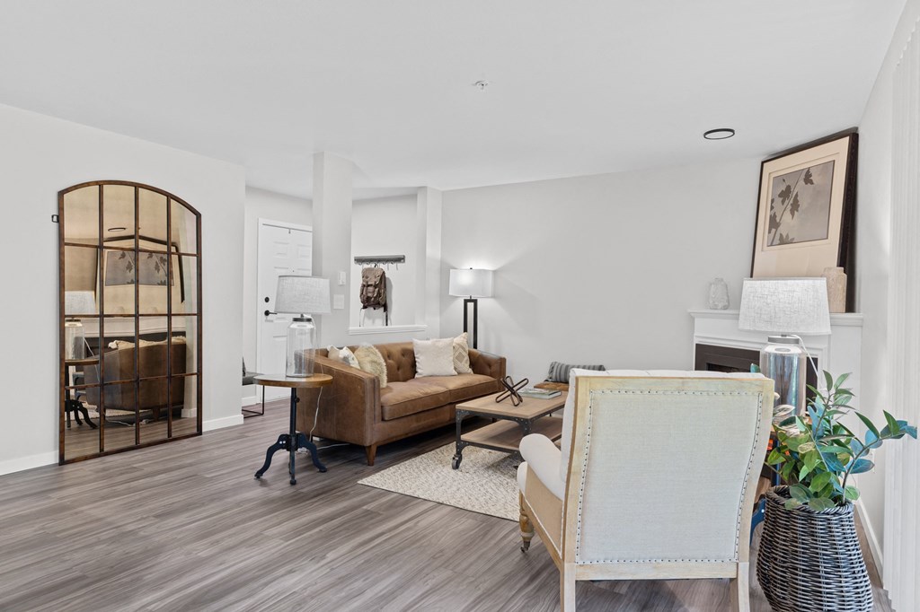 a living room with white walls and hardwood floors