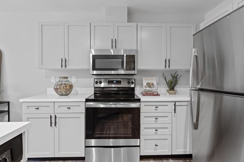 a kitchen with white cabinets and stainless steel appliances