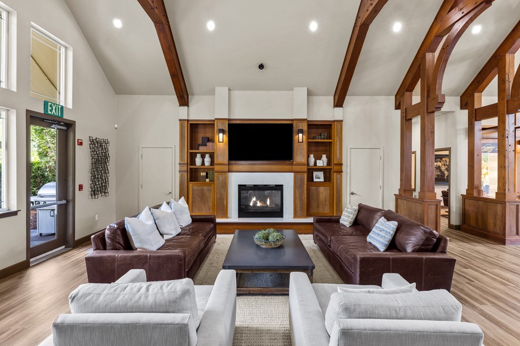 a living room with couches and a coffee table in front of a fireplace