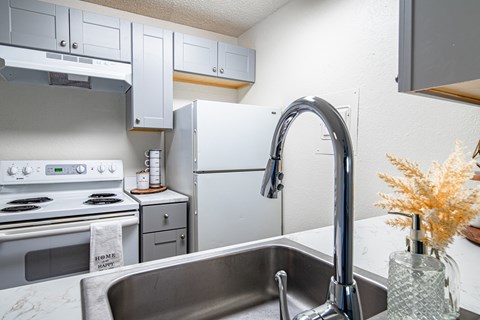 a kitchen with white appliances and a sink