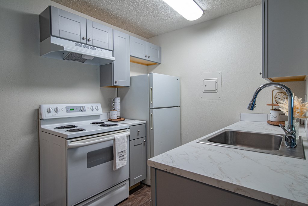 The Willows Apartments kitchen with white appliances and a sink and refrigerator
