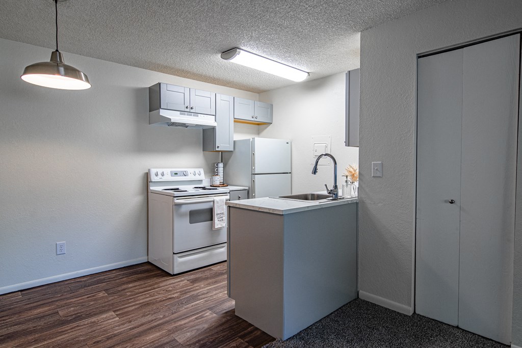 The Willows Apartments kitchen with white appliances and a sink and a refrigerator