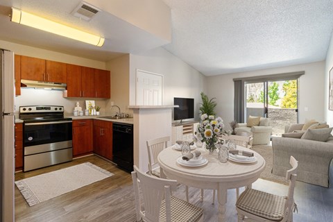 an apartment living room and kitchen with a table and chairs