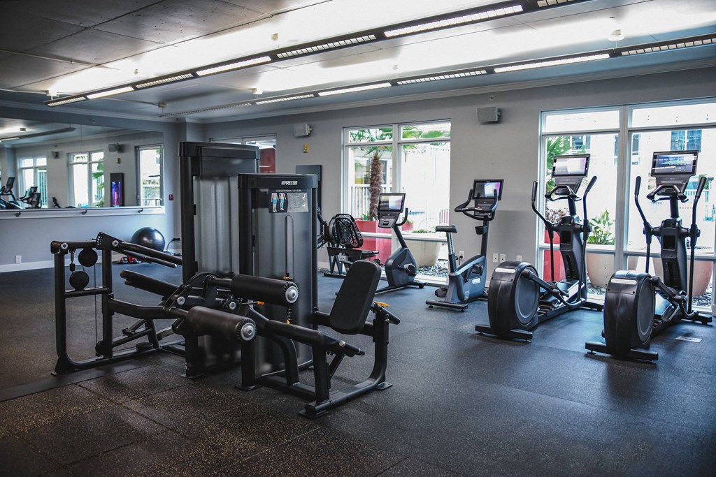 a gym with cardio equipment and weights in a building