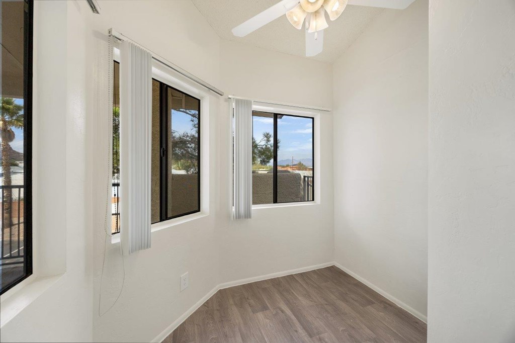 A room with a sliding glass door and a ceiling fan.