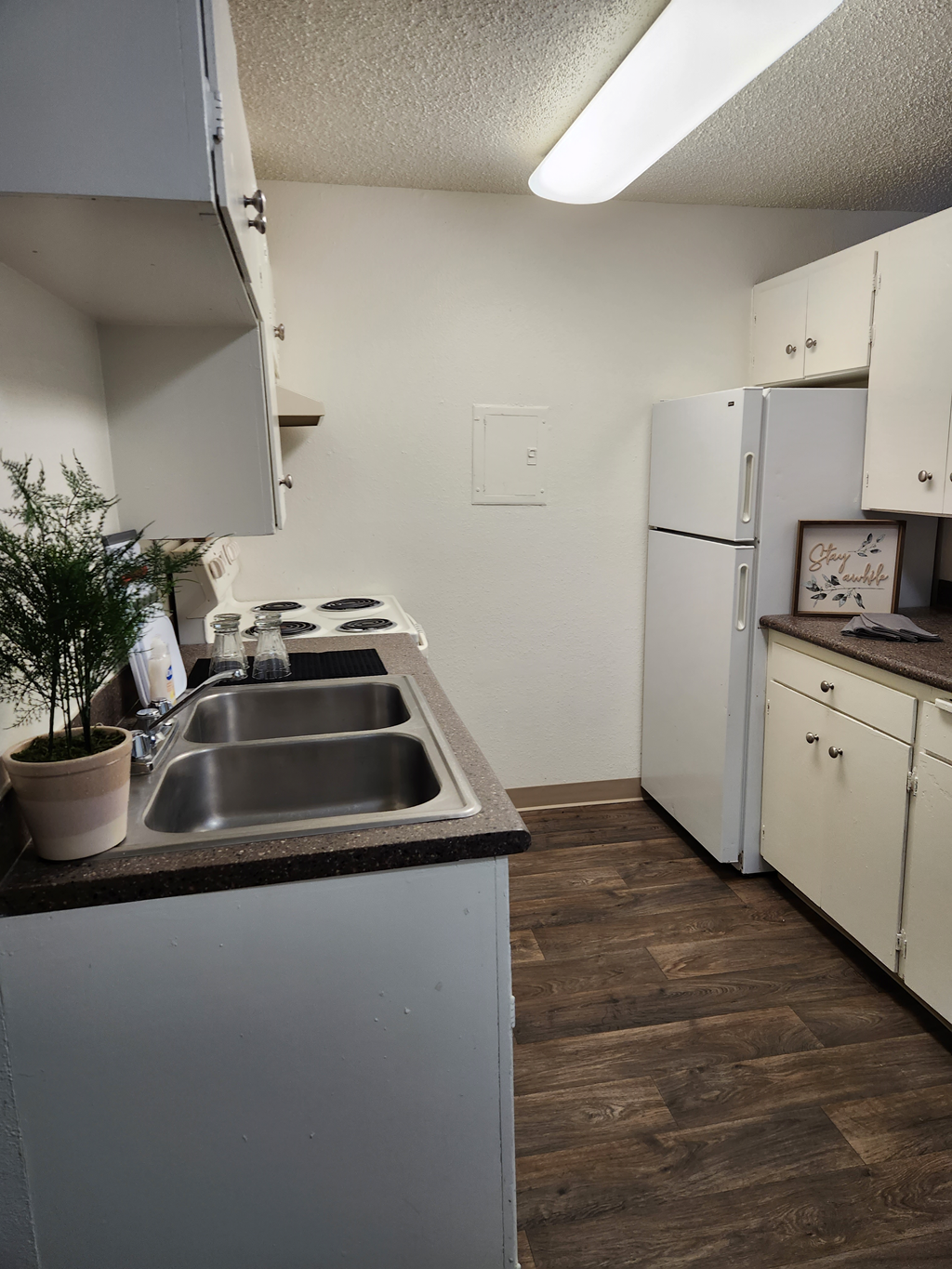Wisteria Walk kitchen with white appliances and a wooden floor