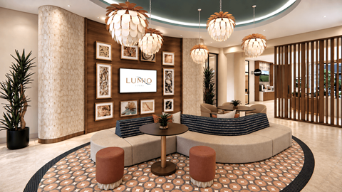 A Lumino sign is on a wall above a couch in a room with a patterned floor.