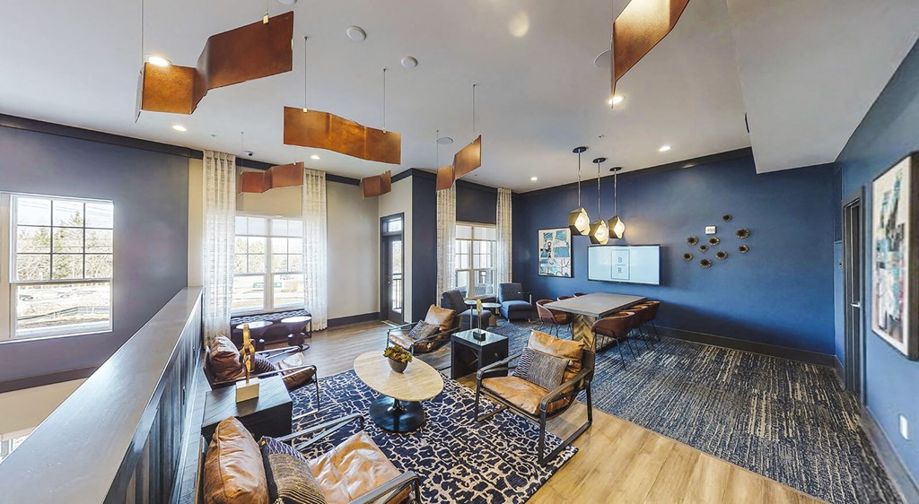 Upper level of resident lounge with meeting table and seating options.