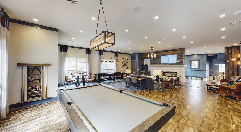 Pool table view of resident lounge and co-working area with couches and a television