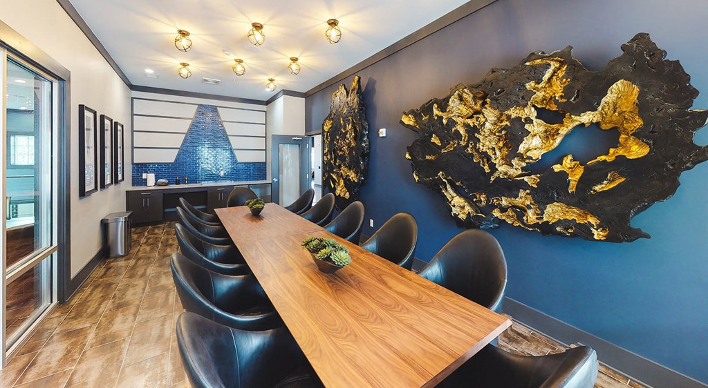 Meeting table with chairs and wall decor at the co-working center with coffee bar.