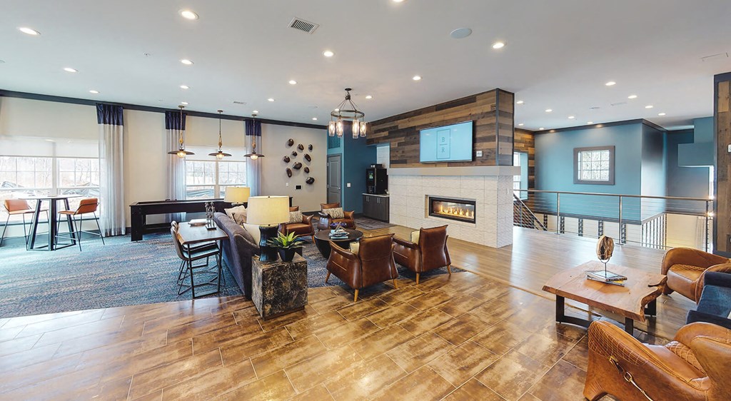 Resident lounge with seating areas, television, and fireplace.