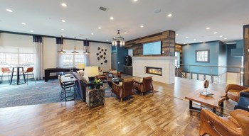 Resident lounge with seating areas, television, and fireplace. - Photo Gallery 4