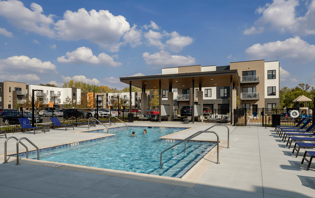 our apartments have a large pool and a building with chairs around it