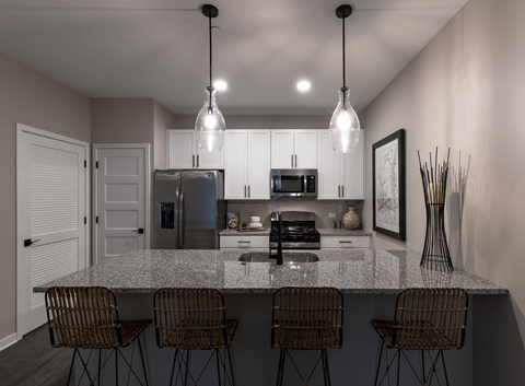 an open kitchen with a granite counter top and a bar with 5 chairs