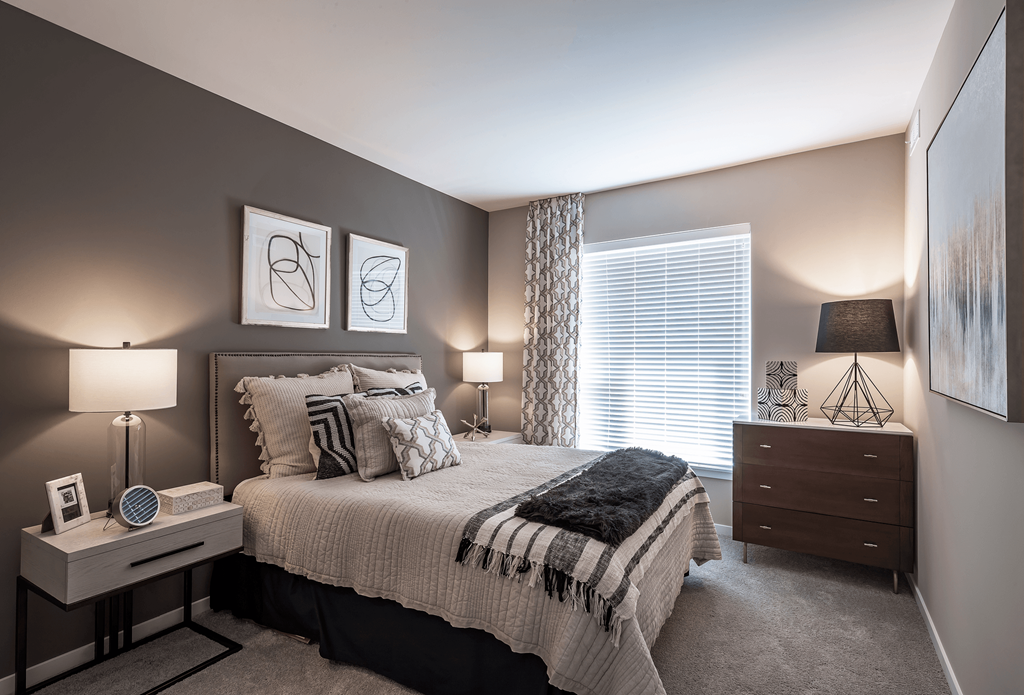 a bedroom with a bed and a dresser and a window