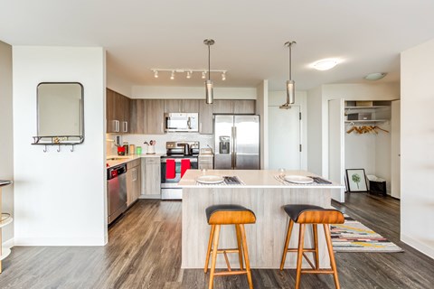 a kitchen with an island and three stools in front of a counter top