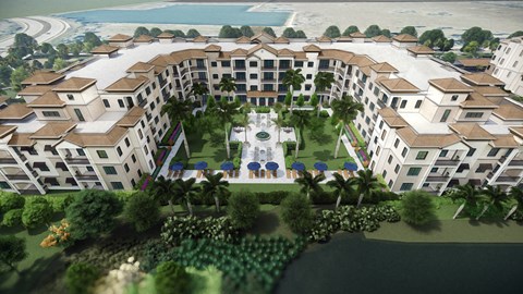 A large, white building with a courtyard surrounded by trees and a body of water.