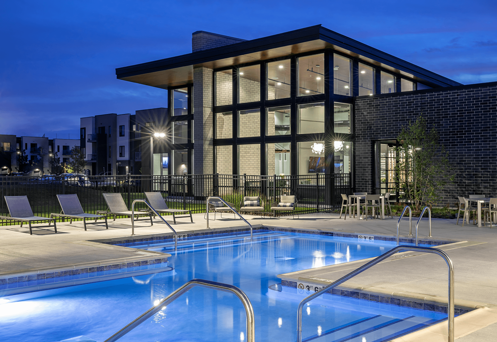 a swimming pool in front of a building at night