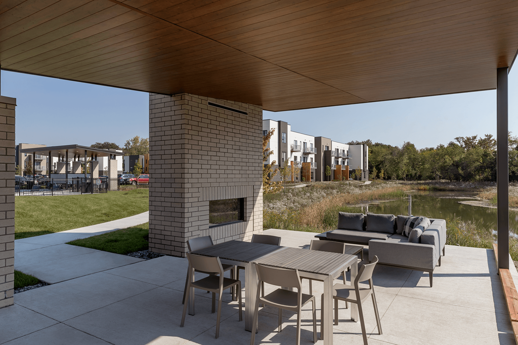 a patio with a table and chairs and a fireplace