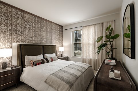 A bedroom with a large bed and a wooden headboard.