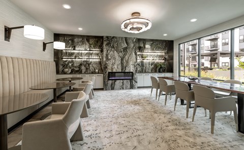 A modern dining room with a long table and chairs.