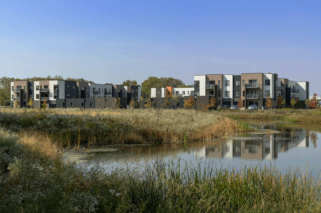 a row of apartment buildings next to a body of water