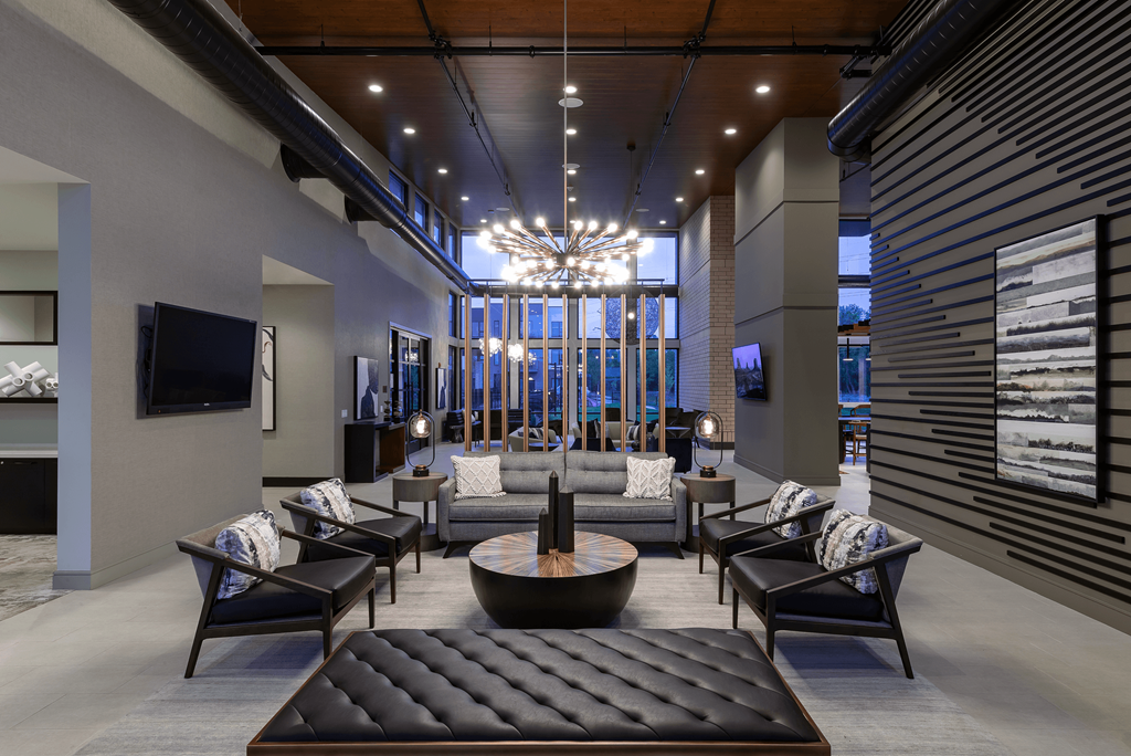 a lobby with couches and chairs and a television