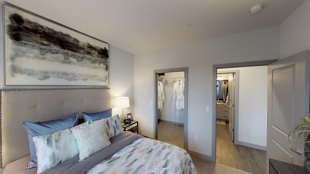 Apartment bedroom with walk-in closet, vinyl plank flooring, and views of the hallway bathroom