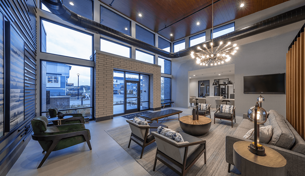 a living room with large windows and a large chandelier