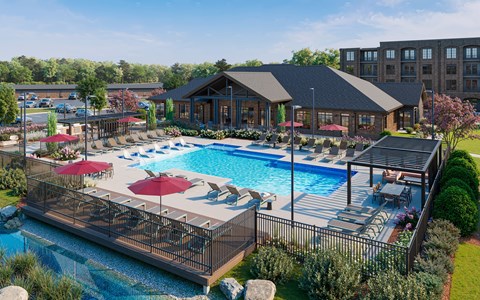 A large outdoor swimming pool with a deck and a building in the background.