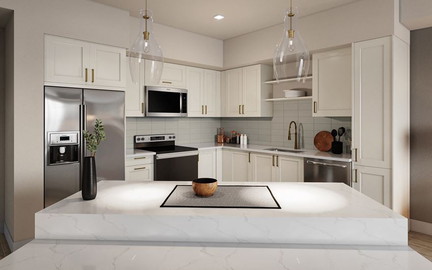 a white kitchen with stainless steel appliances and a marble counter top