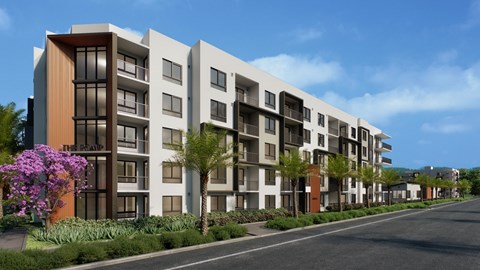 A modern apartment building with a row of trees and purple flowers in front.