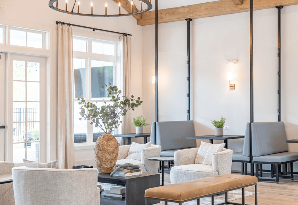 a living room with chairs and tables and a large window