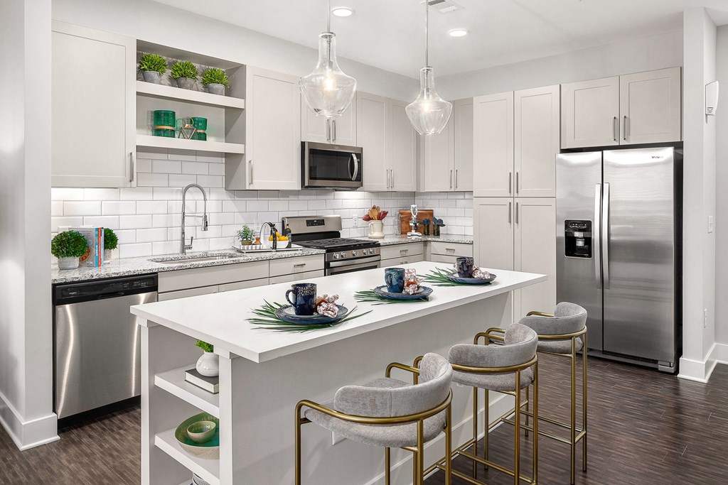 A modern kitchen with white cabinets and a white island.
