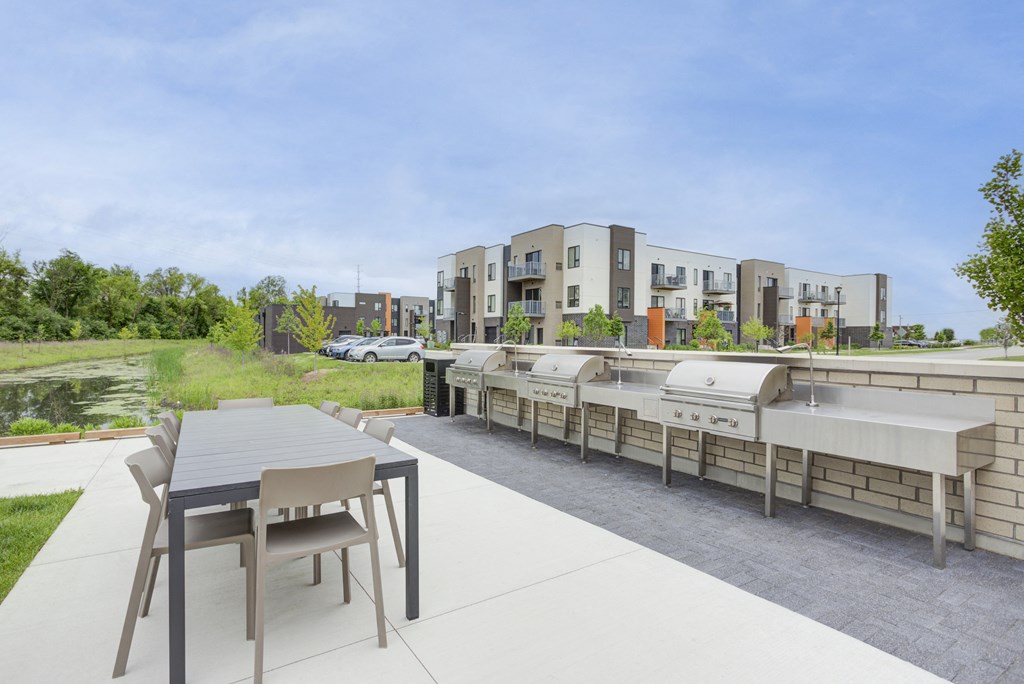 an outdoor patio with tables and chairs and buildings in the background